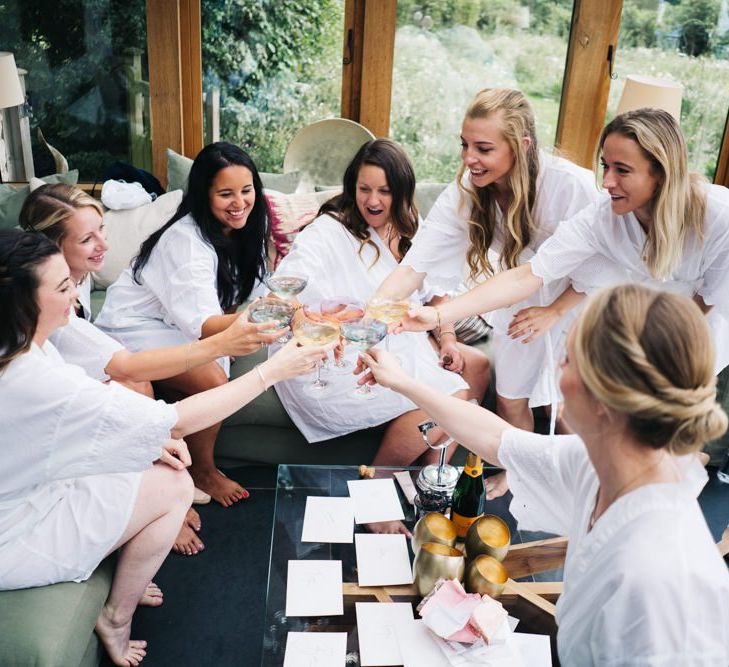 Bridal party toast the days celebration in getting ready robes