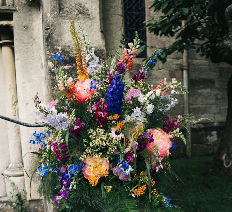 Bright wedding flowers to match bright floral moon gate arch