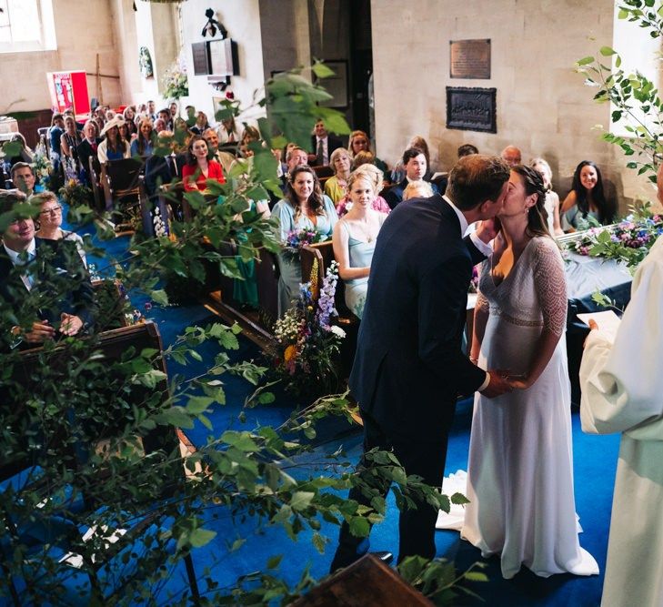 Bride and groom kiss during ceremony