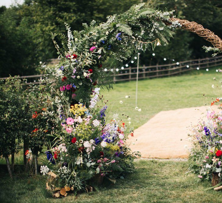 Floral moon gate arch with wildflowers at garden wedding