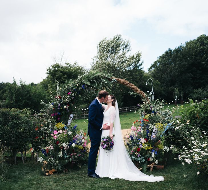 Wildflower floral moon gate arch at marquee wedding