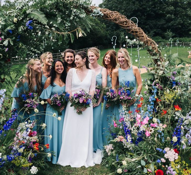 Wildflower moon gate arch with bridesmaids in Rewritten blue bridesmaid dresses