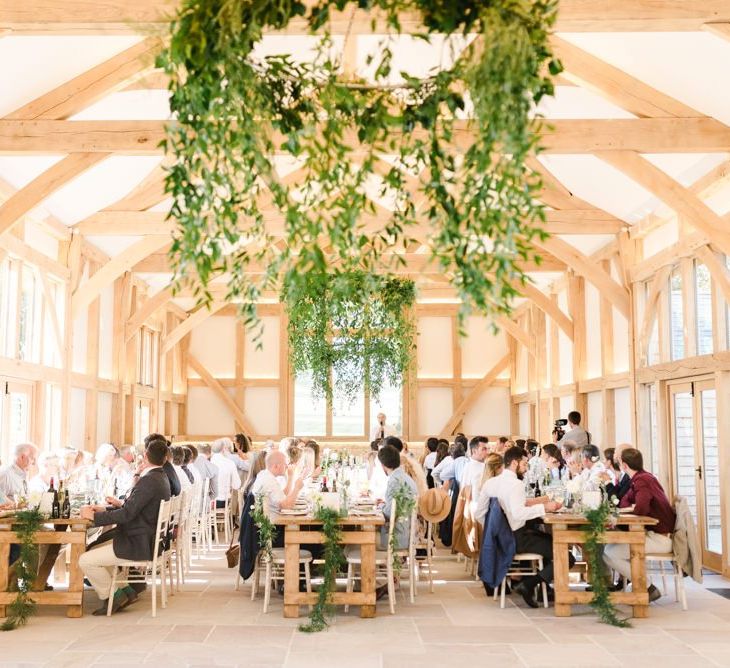 Foliage chandelier and white wedding flowers at barn reception