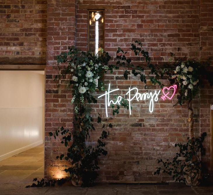 Personalised neon sign and white wedding flowers