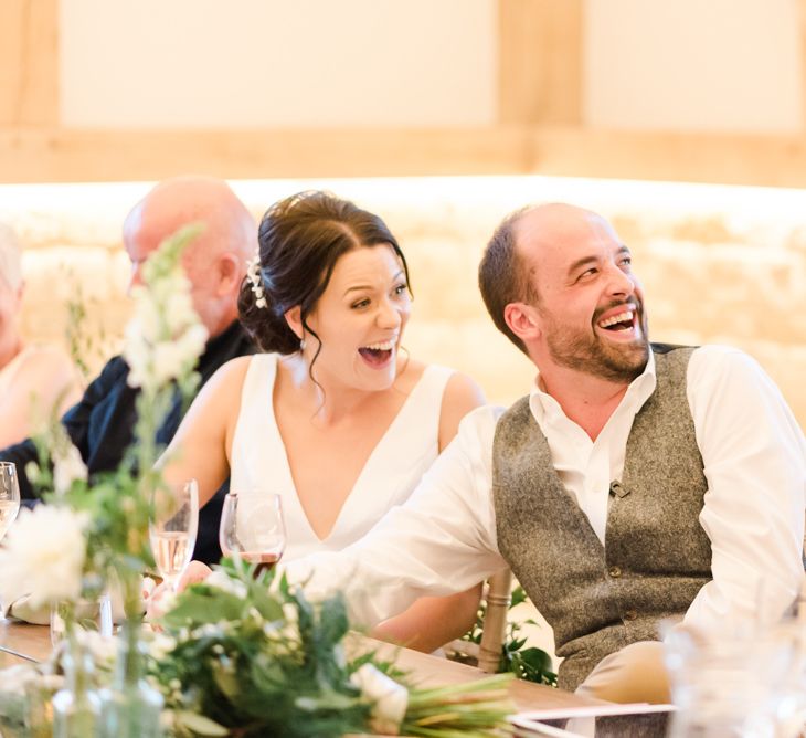 Bride and groom enjoy wedding speeches