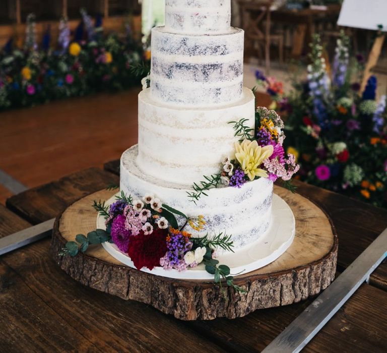 Semi-naked wedding cake with flower decor to match the wildflower moon gate arch