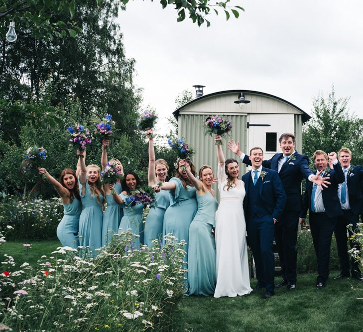 Bridal party in blue dress with groomsmen in matching ties