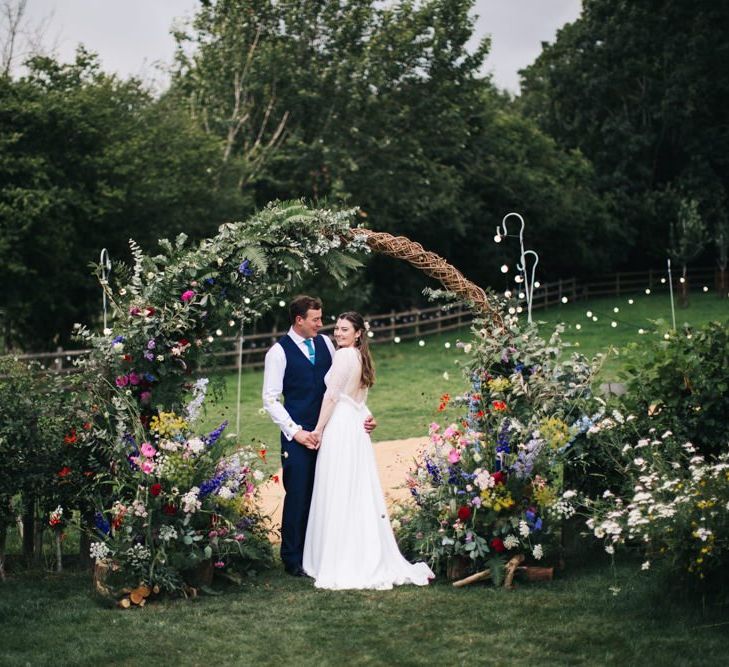 Wildflower moon gate arch at marquee wedding