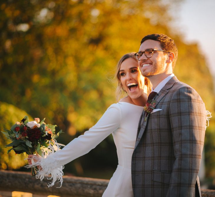 Bride and Groom Smiling with Bride in Pronovias Wedding Dress with Feather Sleeves