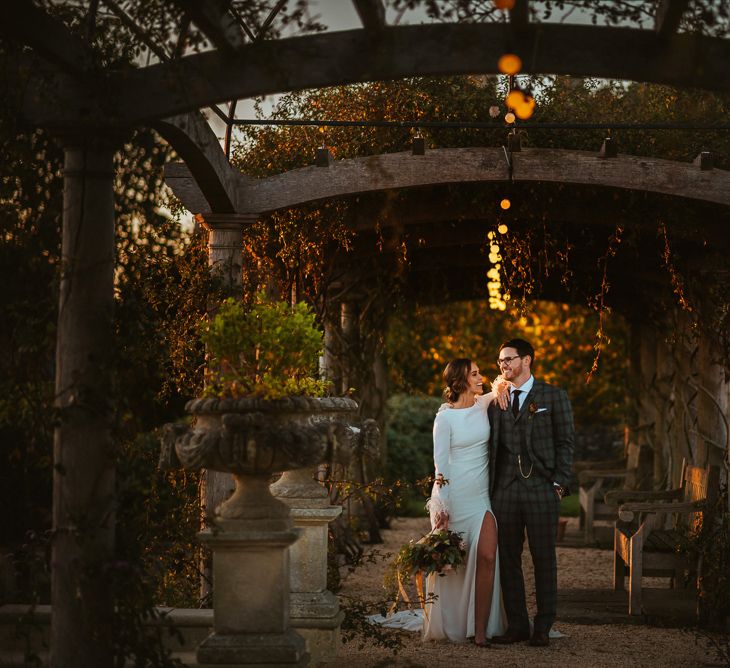 Sunset Wedding Portrait of Bride in Front Slit  Pronovias Wedding Dress and Groom in Christopher Schafer Clothier Suit