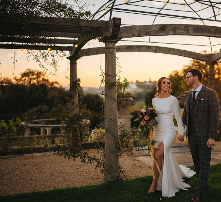 Sunset Wedding Portrait of Bride in Front Slit  Pronovias Wedding Dress and Groom in Grey Checked Suit