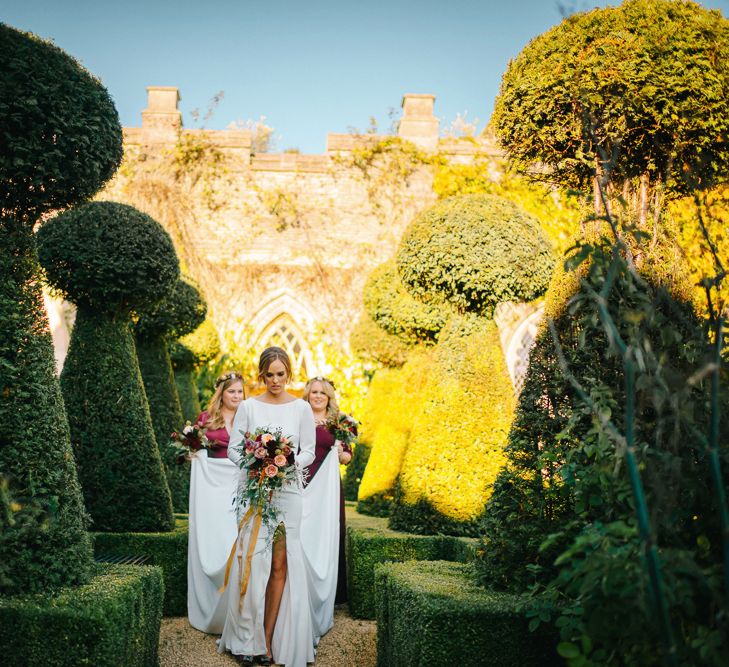 Bride and Bridesmaids Walking Through The Gardens of The Lost Orangery