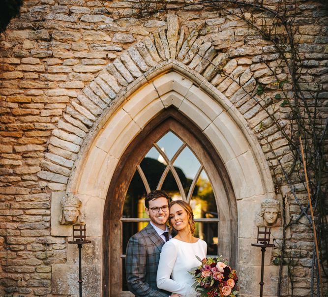 Bride in Pronovias Wedding Dress with Long Sleeves and Groom in Grey Checked Suit