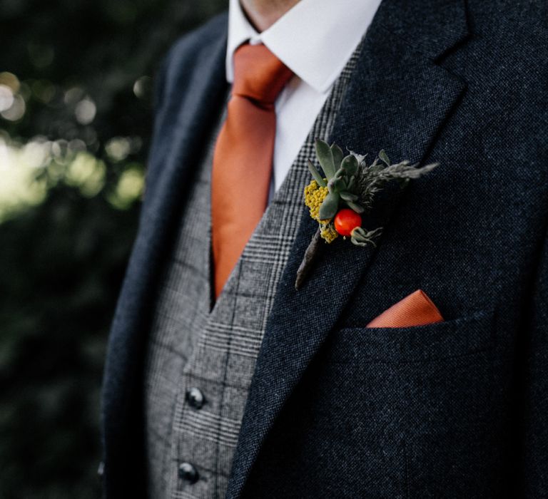 Succulent buttonhole with orange pocket square and tie