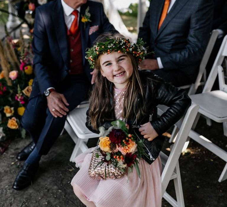 Stylish flower girl in pink dress, flower crown and leather jacket