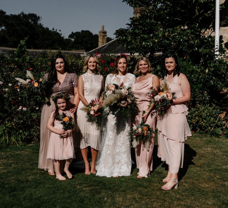 Bridesmaids in different blush pink dresses