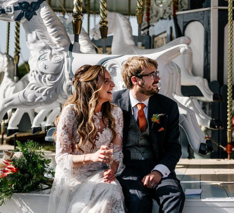 Bride and groom sitting on the carousel Preston Court