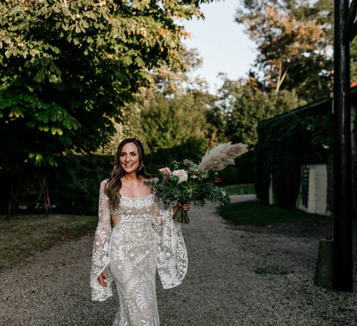 Boho bride in lace Willowby Watters wedding dress