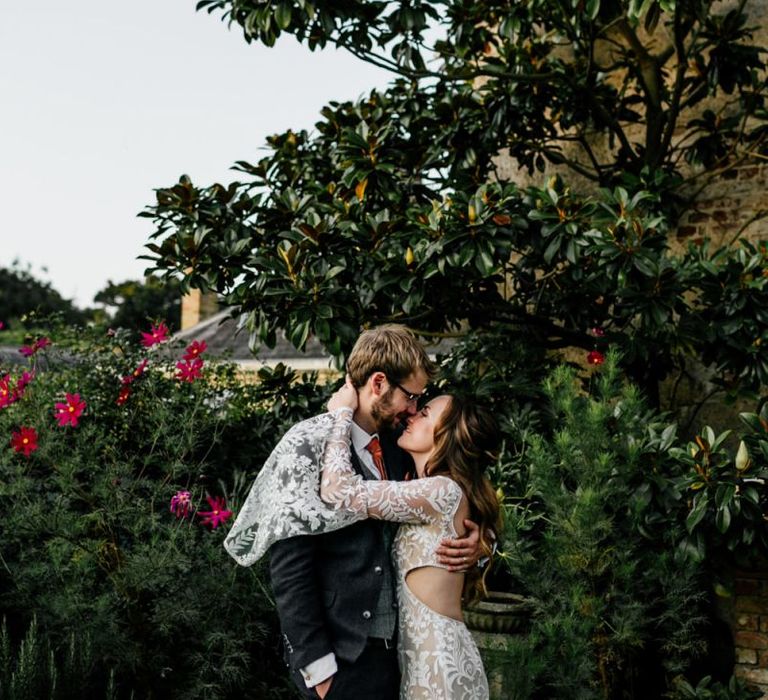 Bride in Willowby Watters wedding dress with bell sleeves  hugging her groom