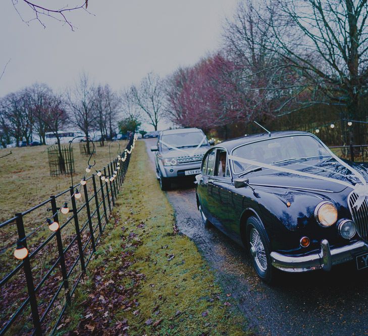 Vintage wedding car driving up the church lane