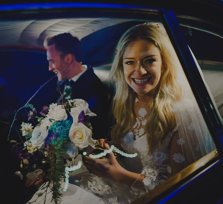 Happy bride sitting in the wedding car