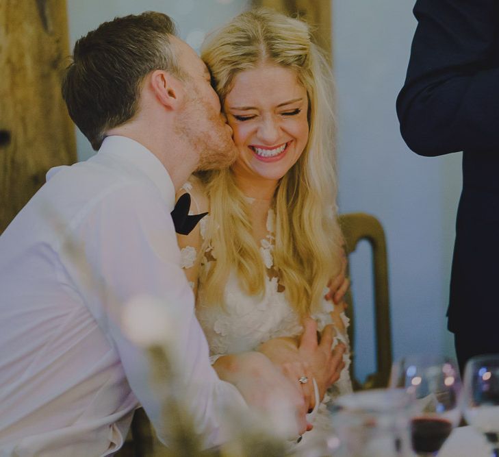 Groom kissing his bride on the cheek during the wedding speeches