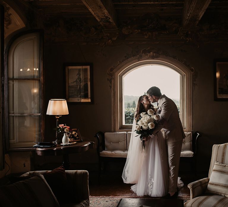 Bride and groom with large white rose bouquet