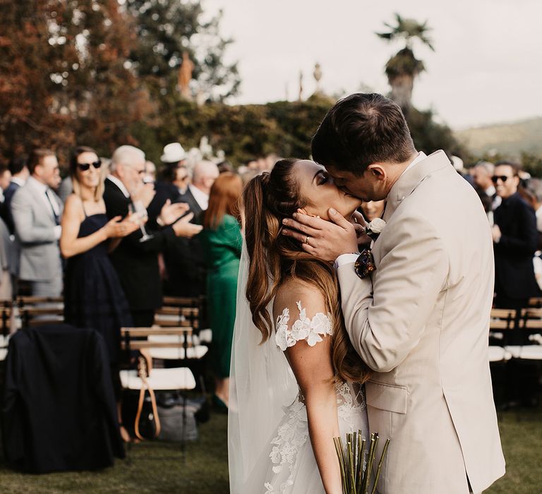 Bride in Galia Lahav wedding dress kisses groom