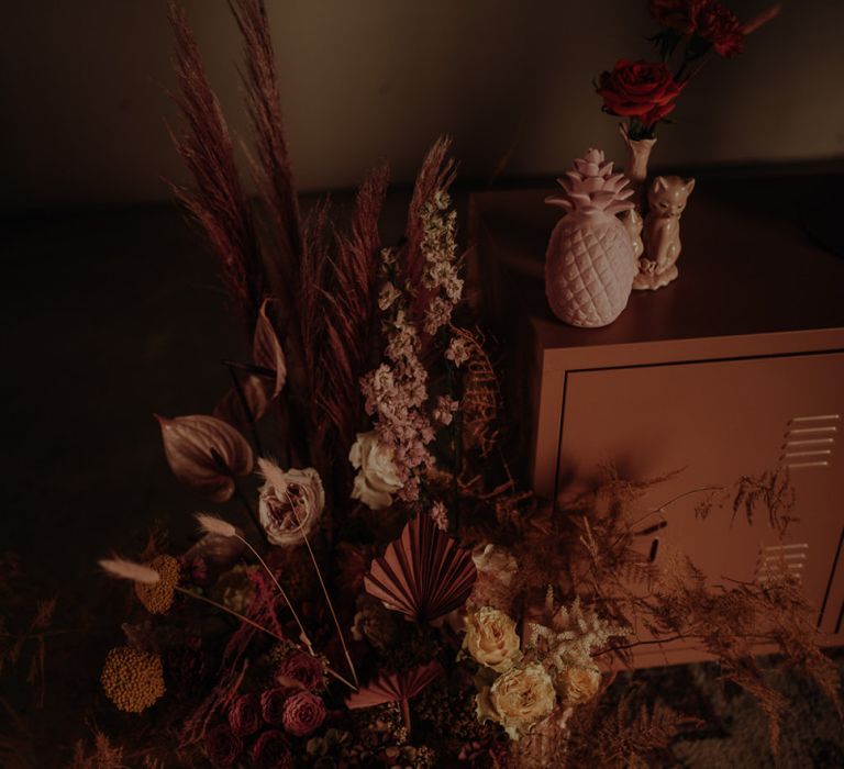 Pink floral arrangement with dried grasses, anthuriums  and roses