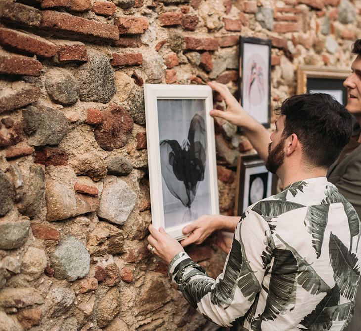 Groomsmen Putting Up a Gallery Wall Wedding Decor