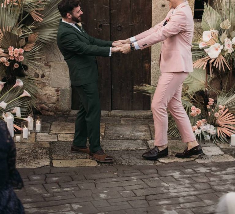 Same Sex Wedding Ceremony with Two Grooms in Green and Pink Wedding Suits