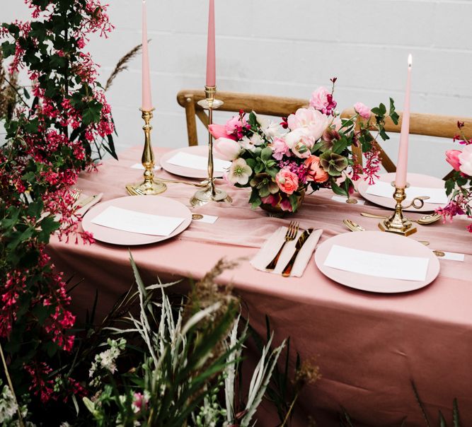 Table Decor with Pink Table Cloth, Pink Tableware, Pink Taper Candles, Gold Cutlery and Deep Pink and Foliage Wedding Flowers