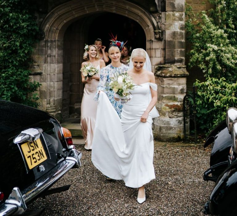 Bride in off the shoulder wedding dress going to the church