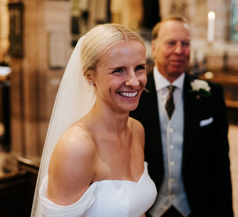 Bride smiles at someone off-camera