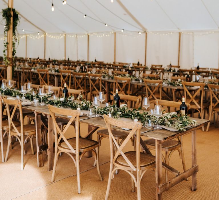 Hanging festoon light installation with foliage decor