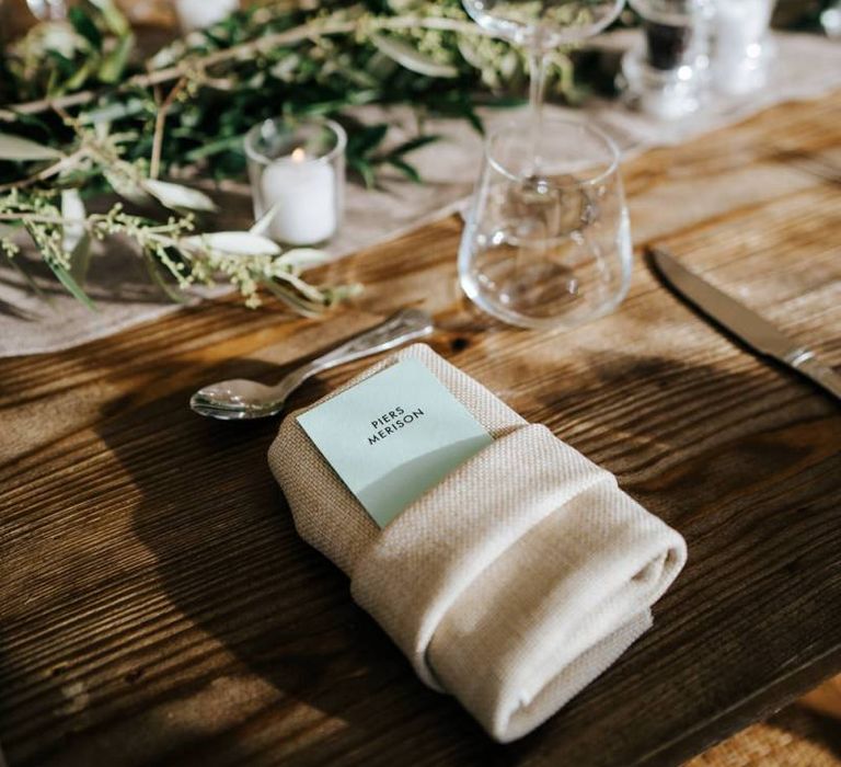 Close-up of placecard and decoration on wooden table to be used for wedding breakfast