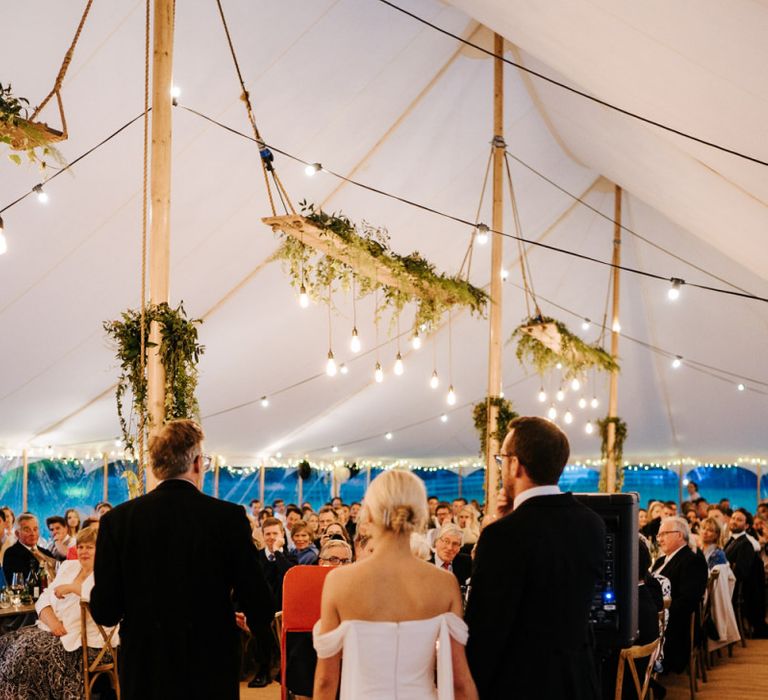 Father of the bride delivering his speech as guests listen attentively inside marquee at Hawarden Castle, Wales