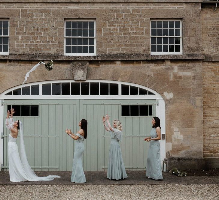 Bride In Strapless Wedding Dress Throws Bouquet To Bridesmaids