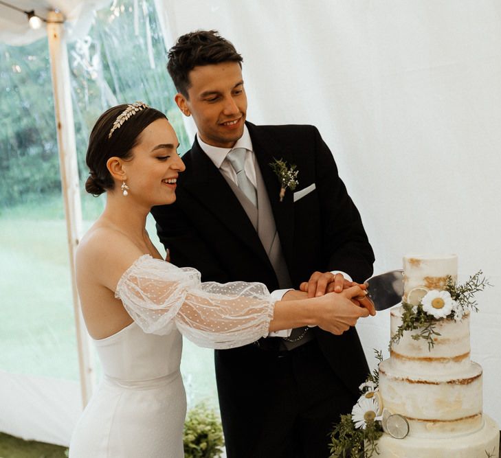 Bride In Strapless Wedding Dress Cuts Cake With Groom