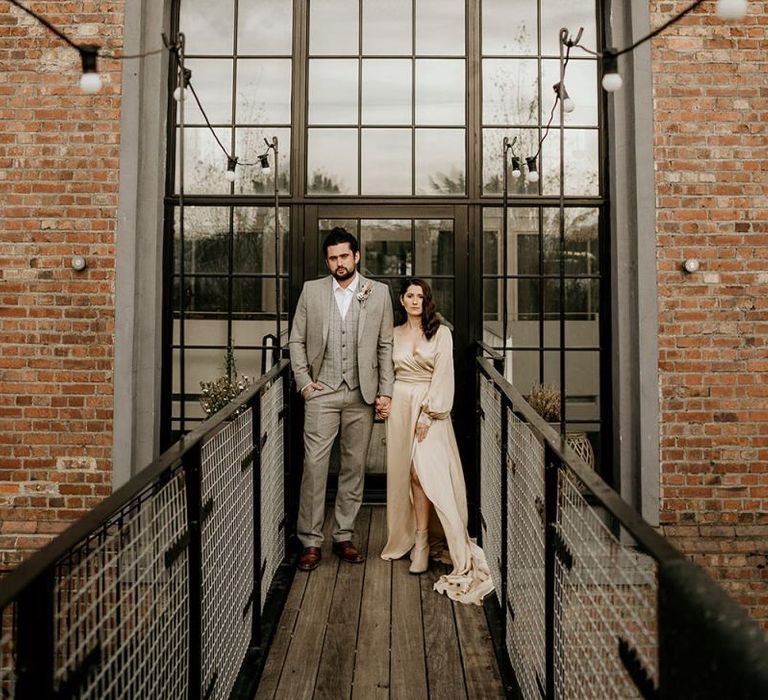 Stylish Bride and Groom Standing Outside Industrial Wedding Venue The Winding House