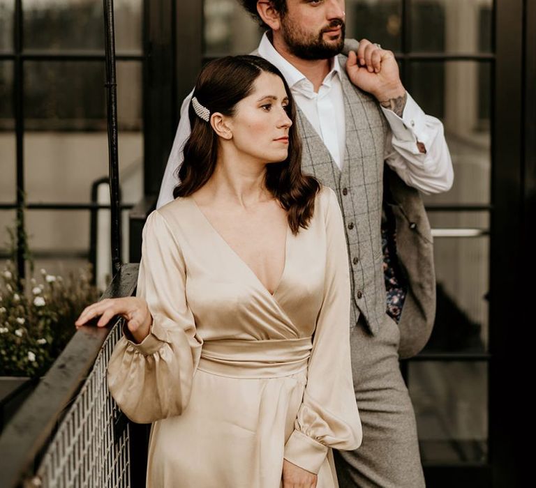 Bride in Oyster Satin Wedding Dress and Peal Hair Slide and Groom in Check Waistcoat with a Top Knot