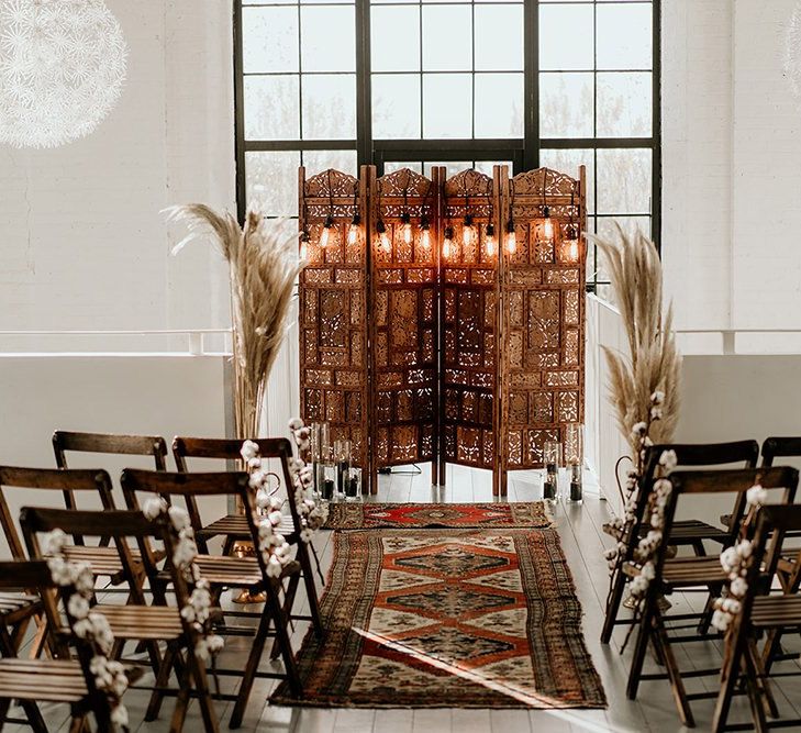 Industrial Wedding Ceremony Setup with Wooden Chairs, Screen Altar and Wool Rug Aisle Decor