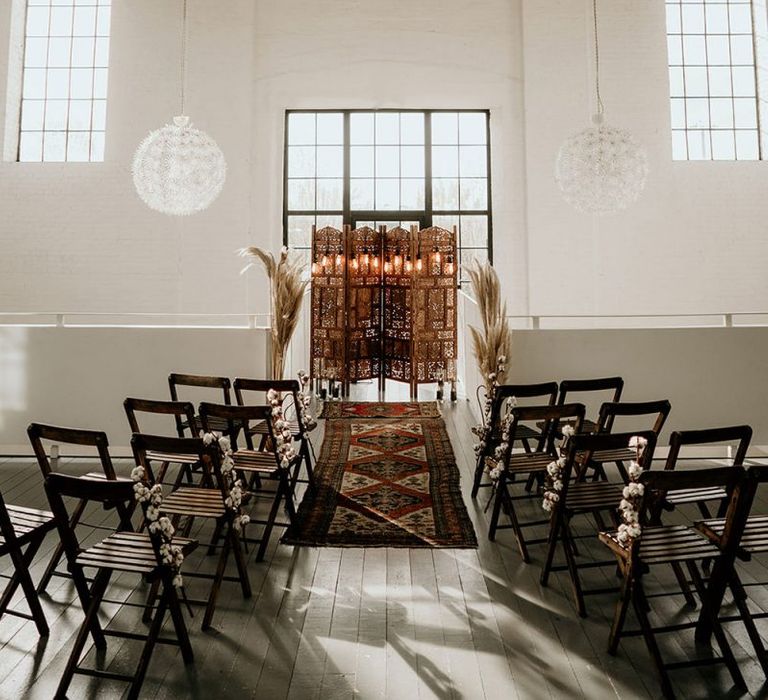 Industrial Wedding Ceremony Setup with Wooden Chairs, Screen Altar and Wool Rug Aisle Decor