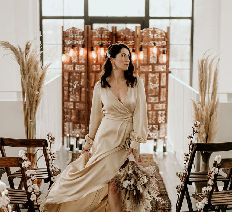 Stylish Bride in Satin Wrap Wedding Dress and Peal Hair Slide Standing in Front of a Moroccan Screen and Rug