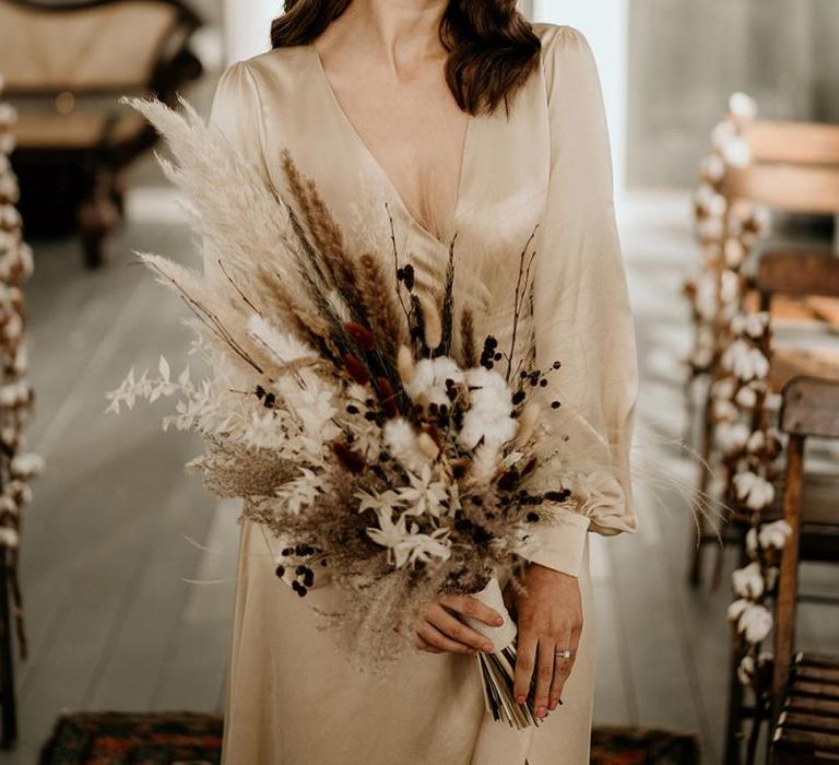 Elegant Bride in Satin Wedding Dress Holding a Dried Flower Wedding Bouquet