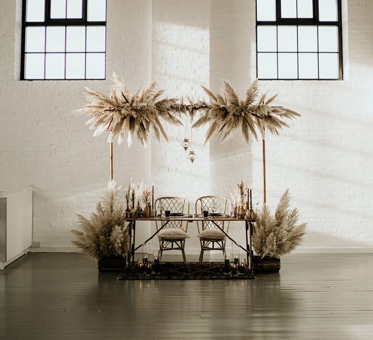 Sweetheart Table in an Industrial Venue with Pampas Grass Installation and Floral Arrangements