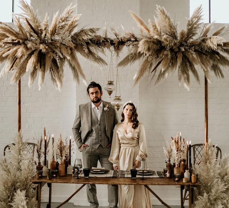 Sweetheart Table Decorated with Pampas Grass installation, Vessels Filled with Dried Grasses and Persian Rug