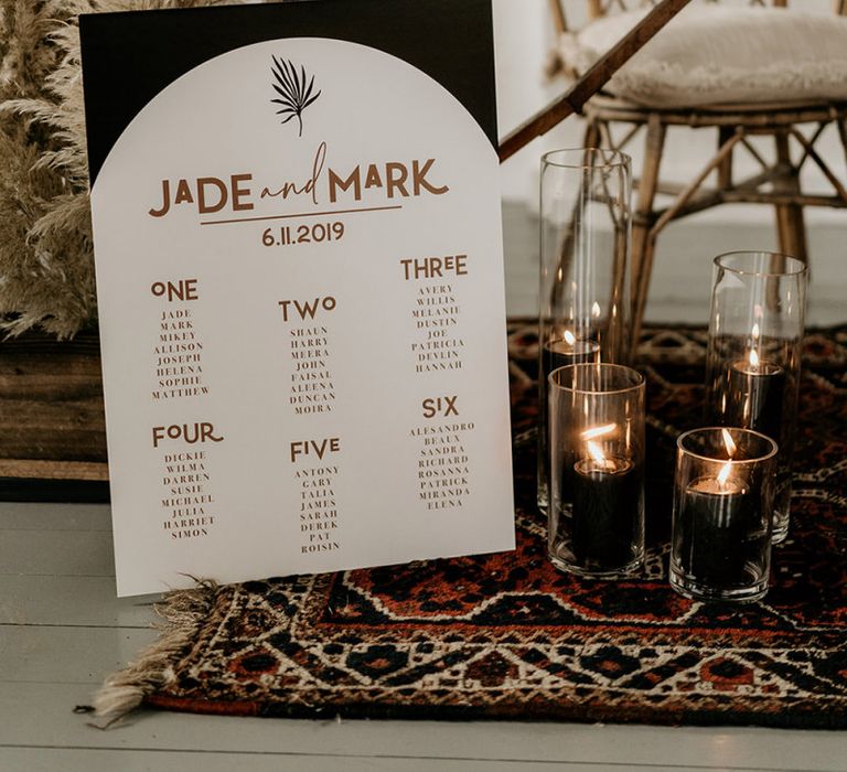 Contemporary Black and Gold Seating Chart Surrounded by Candles