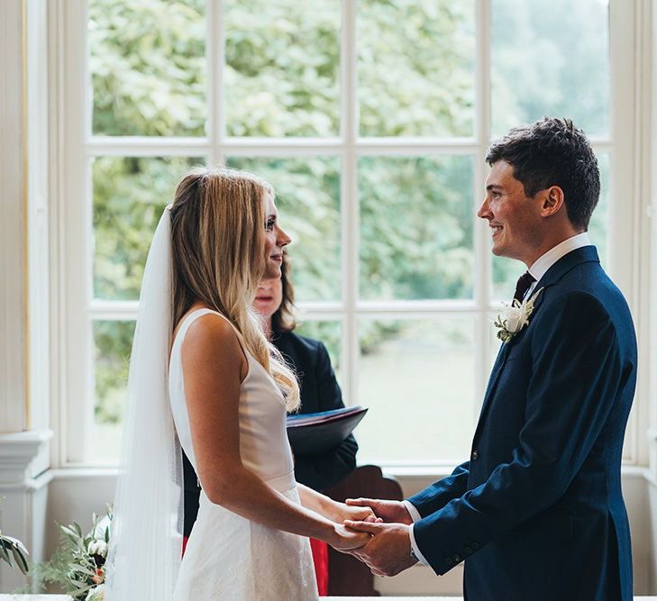 Bride in Charlie Brear Tiered Lace Wedding Dress with Groom in Hackett Suit