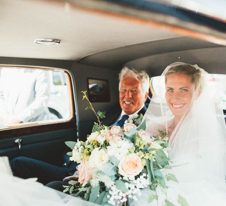 Beautiful Bridal Entrance in Wedding Car Holding White and Peach Bouquet